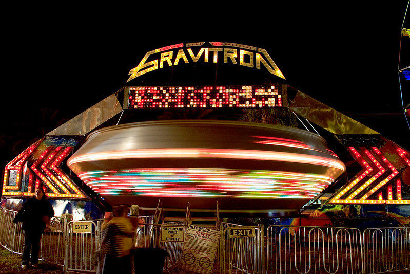 The carnival ride Gravitron spins at nighttime